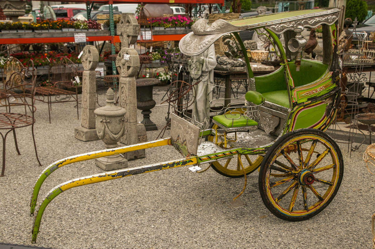 Beyond colorful and fully functional child's rickshaw. Tin and silver-plated metal with fine filigree trim decorates the entire piece.
This super fun piece of history, has a bright color scheme and classic details. It gives you a tremendous Asian