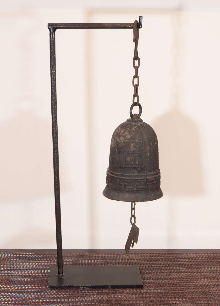 A beautifully embossed early 19th Century Chinese cast iron bell suspended from original chain and mounted on custom iron stand. China, Shanxi Province, c. 1800.
M662