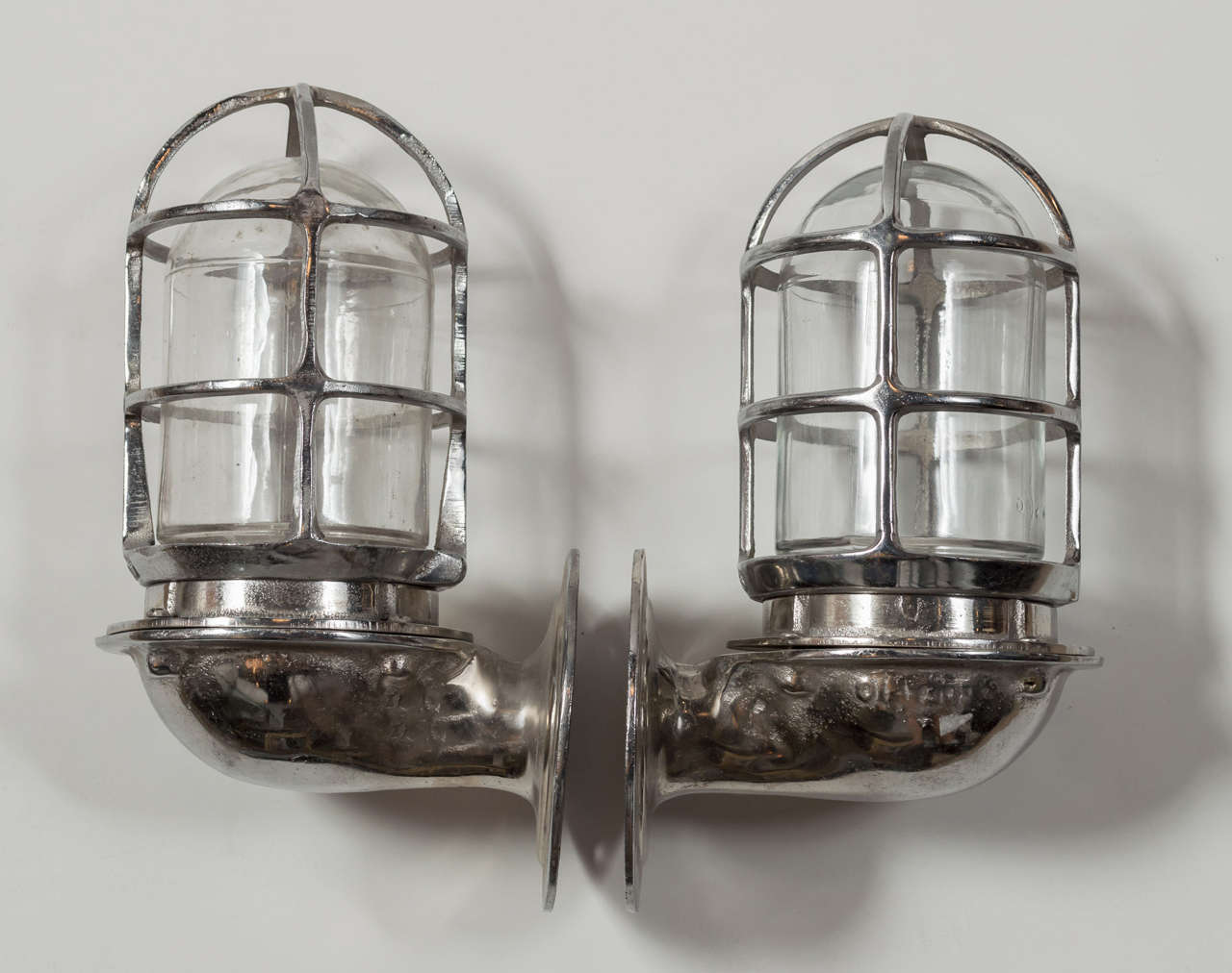 Pair of maritime sconces from France, circa the 1920s. Glass globe with metal cage, wall mounts are circular with a 4.5