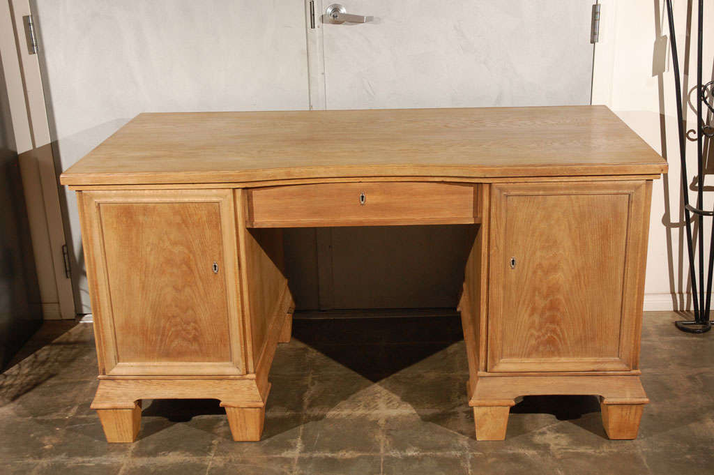 A good French early 20th century two pedestal oak desk having a center indent. The desk boldly stands on raise feet and being in a light finish will help brighten any setting. The French Oak Desk Made of Oak and secondary wood with a center and