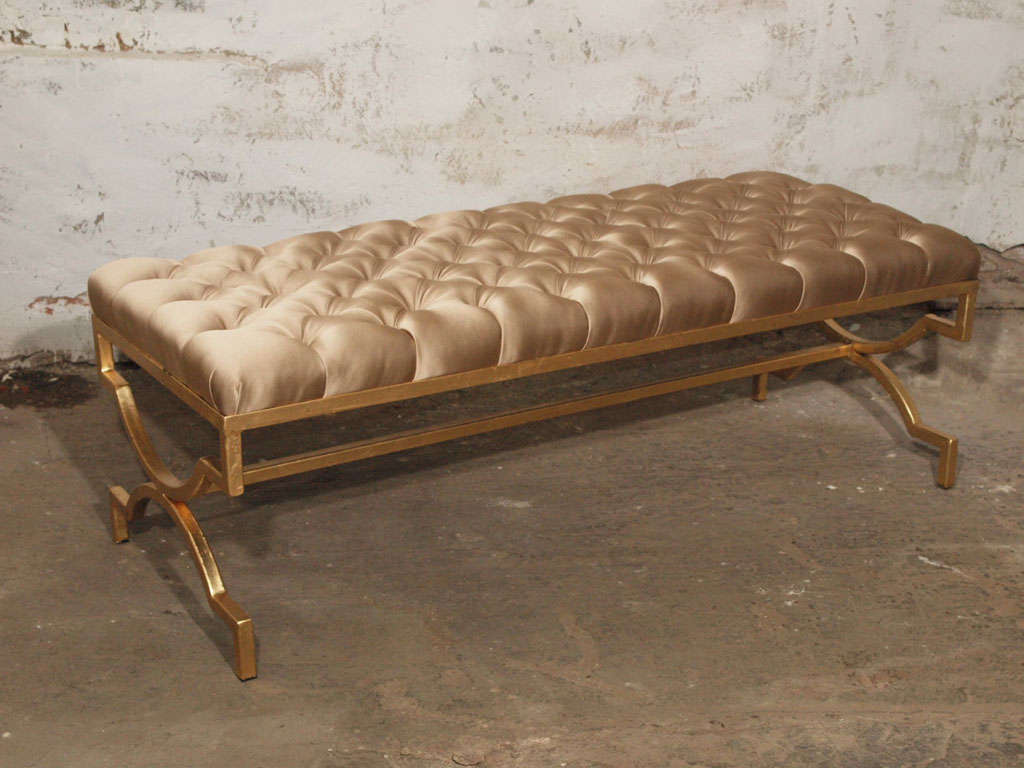 Elegant and very glamorous mid-century modern style iron bench gilded in 24k gold leaf.  Newly upholstered in a thick antique gold silk and button tufted.  Clean and elegant lines.  Would look gorgeous at the foot of a bed, as a coffee table or an