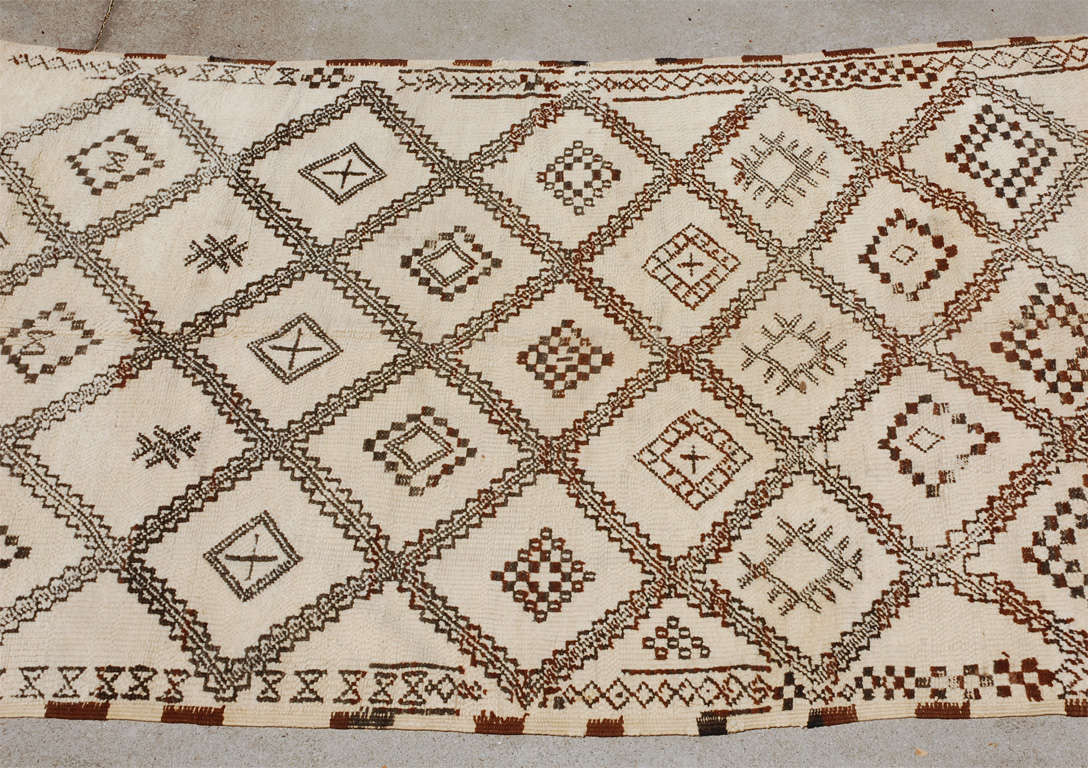 Vintage Moroccan Area Rug.
Cream color field with a modern geometric lattice with light browns color lozenges and naif designs, the colors are muted and lightened from one area to the other end.