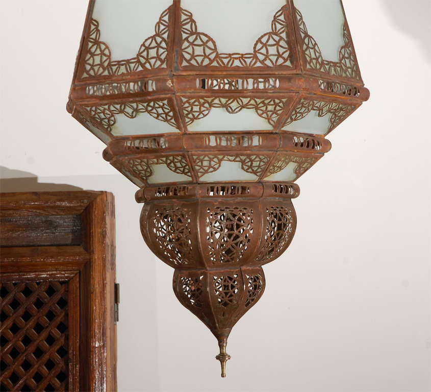 Great vintage Moroccan hand-crafted glass lantern with fine Moorish filigree work, milky glass.
Rewired with a cluster of 3 lights.
Comes with chains and canopy, chains could be adjusted to your needs.
We have a pair available, price is for 1.