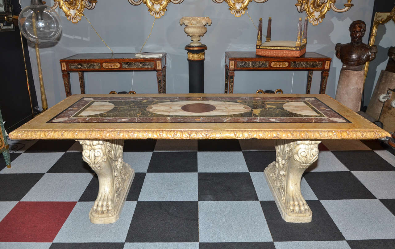 Large 1940s marble table in three parts: top surface in marquetry of black and white marble, porphyry, alabaster green and Sienna yellow; two travertine legs decorated with lion's claws.