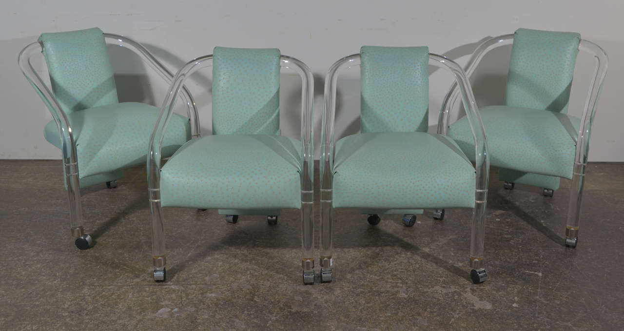 Set of four dining/game chairs on casters. These chairs are bent Lucite with faux turquoise ostrich. In the style of Charles Hollis Jones.