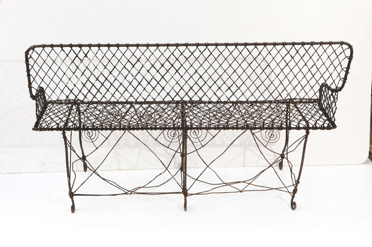 Antique wirework bench from England, ca. 1900.  Frame of solid rod iron with woven seat and decorative apron in heavy gauge wire. Very sturdy, in great  condition.
Previosly priced at $2000.00 now sale priced at $1400.00.
No further reductions.