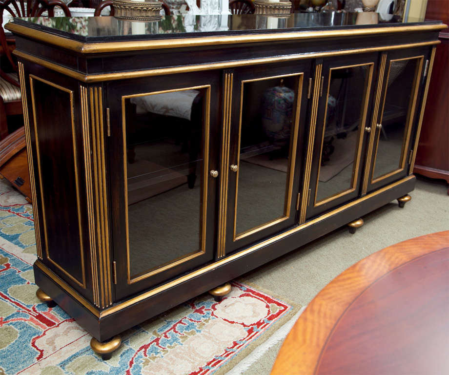 Burnished ebony display cabinet with gilt trim, glass doors, lights inside and glass framed shelves.  Interior lights dimmable by touching hinges.  Granite top.