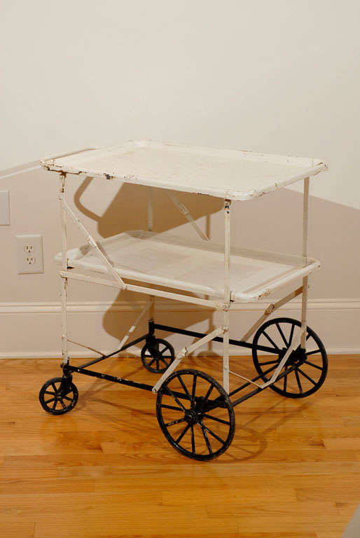 Vintage white metal apothecary cart with black accents. Makes for an unusual drinks trolly.