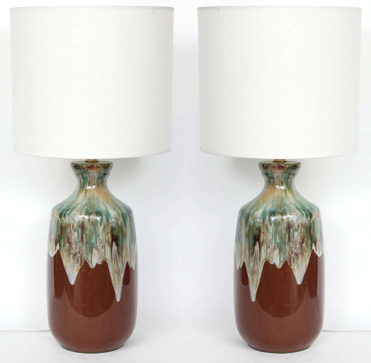 Fantastic pair of Danish Modern ceramic lamps featuring a rust color glaze and a wonderful blend of greens, browns and cream around the neck. Rewired for use in the USA. 100W max each lamp.