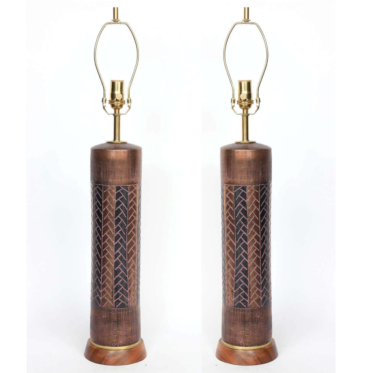 Pair of Italian ceramic lamps with a graphic pattern glaze with incised details. Lamps are on a turned walnut base and have been rewired for use in the USA with brown silk cords.