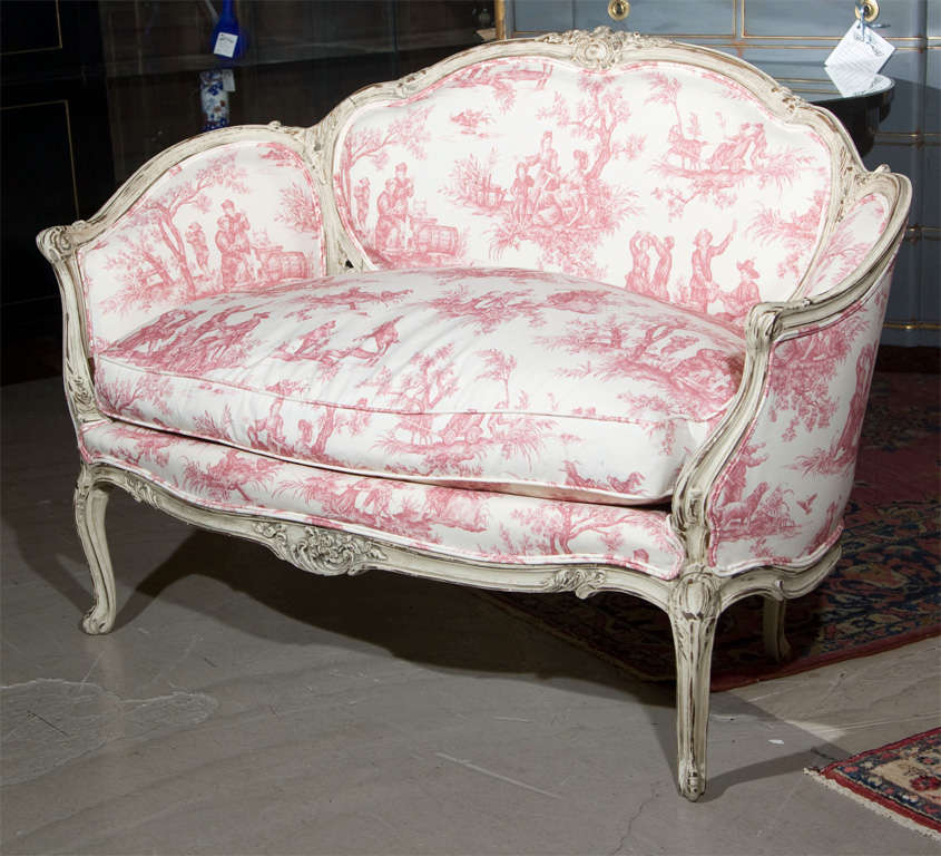 A very sweet distress-painted settee in the taste of French Louis XV, upholstered in toile fabric, stamped Jansen.