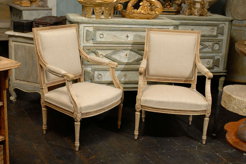 A pair of French Armchairs in a bleached finish. New upholstery.
Upholstery chosen by the owner is intended to be a temporary state to display the chairs in a neutral tone.
Dimensions are: 24.5
