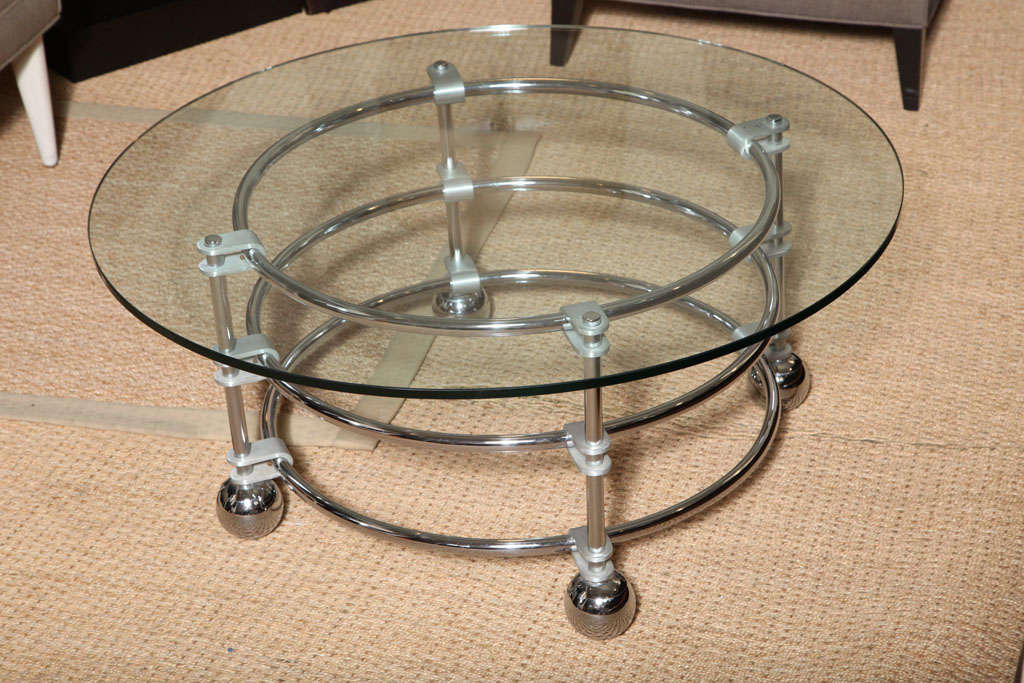 Round glass top cocktail table with polished chrome base on large ball casters by Jay Spectre, 1980s.