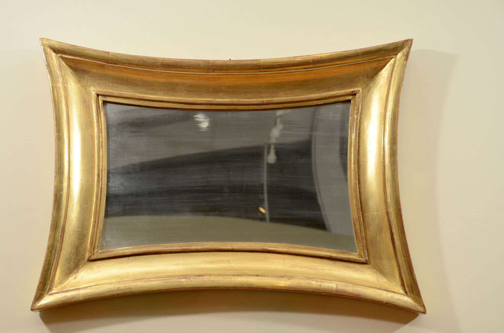 A Swedish giltwood mirror, Circa 1860s, with concave sides and a cove section frame.