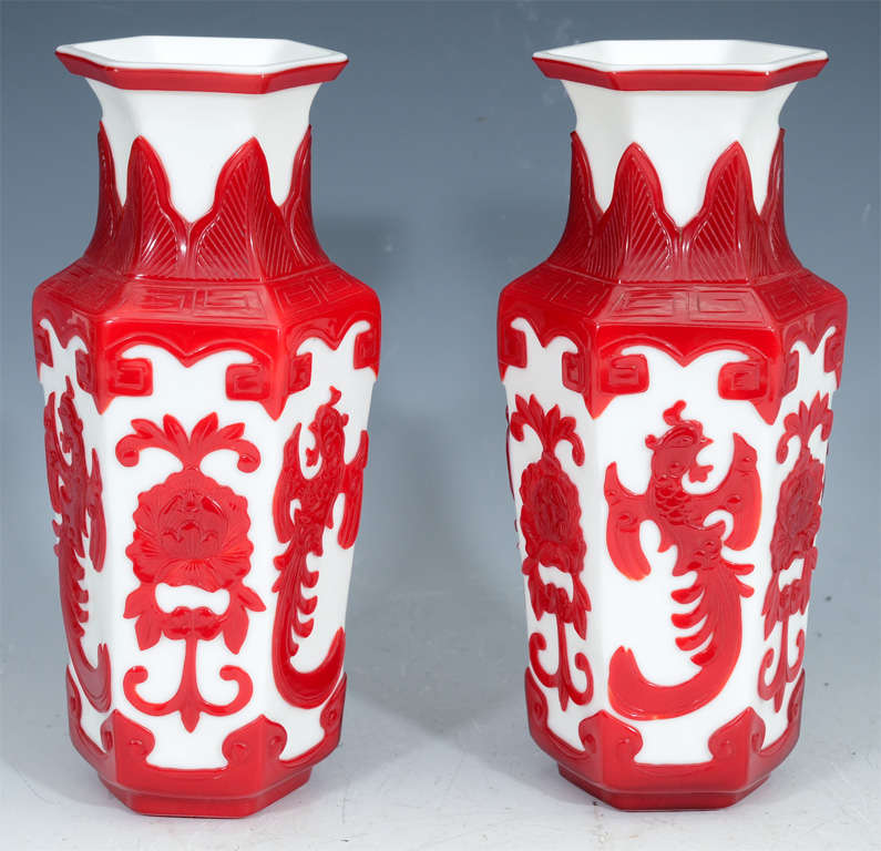 A pair of red on white backbround cut glass vases with floral and dragon motif.