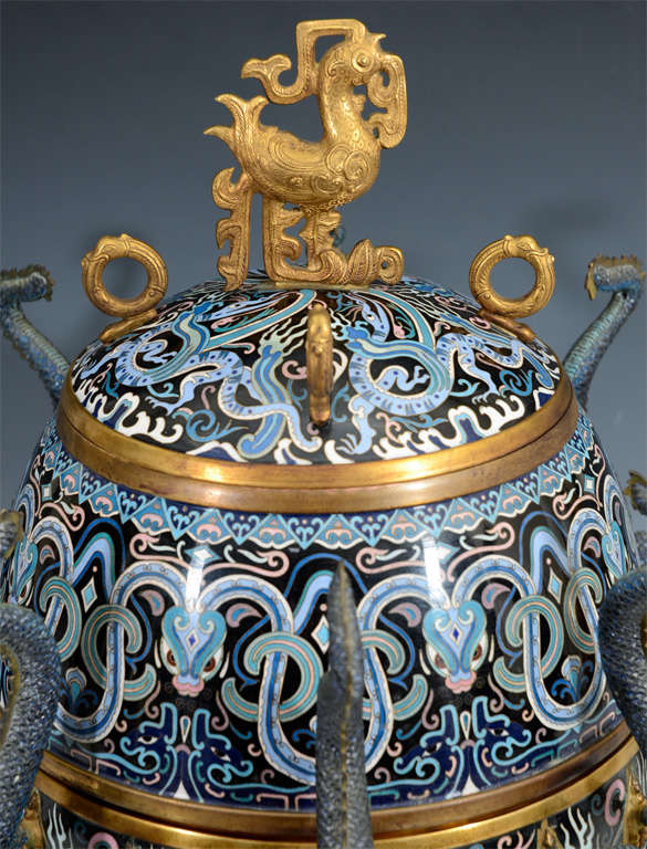 A Chinese Ching Dynasty jar or censer with elaborate, blue cloissone design of intertwined dragons and eight dragon form handles. The piece has gold detailing and two interior compartments.