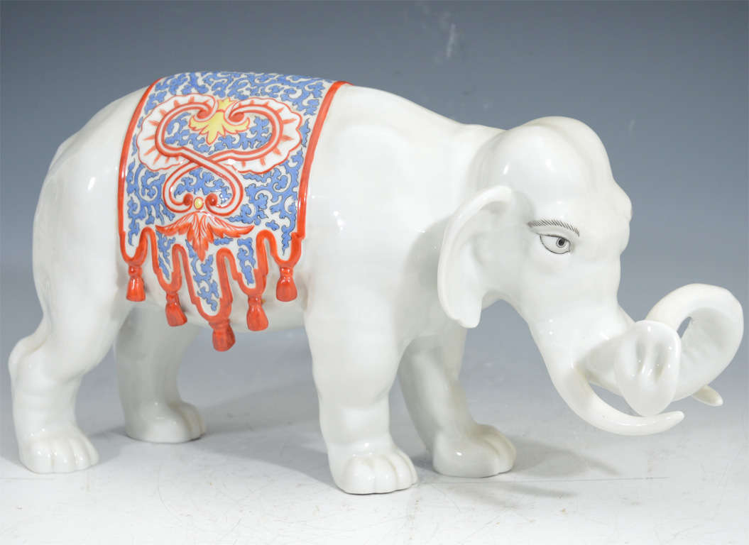 A Japanese decorative porcelain elephant with red and blue vegetal motif blanket detail.

4383