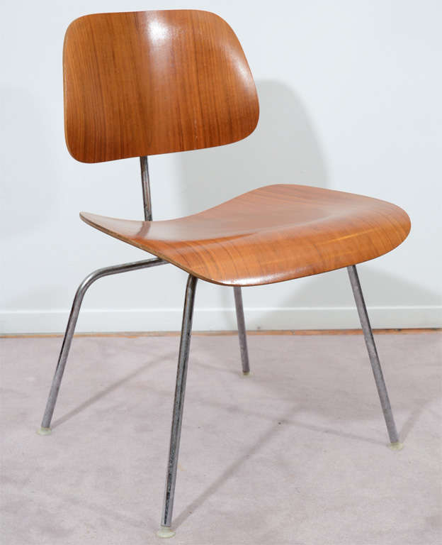 A set of five classic DCM chairs by Charles Eames for Herman Miller. The chairs are in a walnut veneer with metal frame and each has the Herman Miller label on the bottom of the seat.