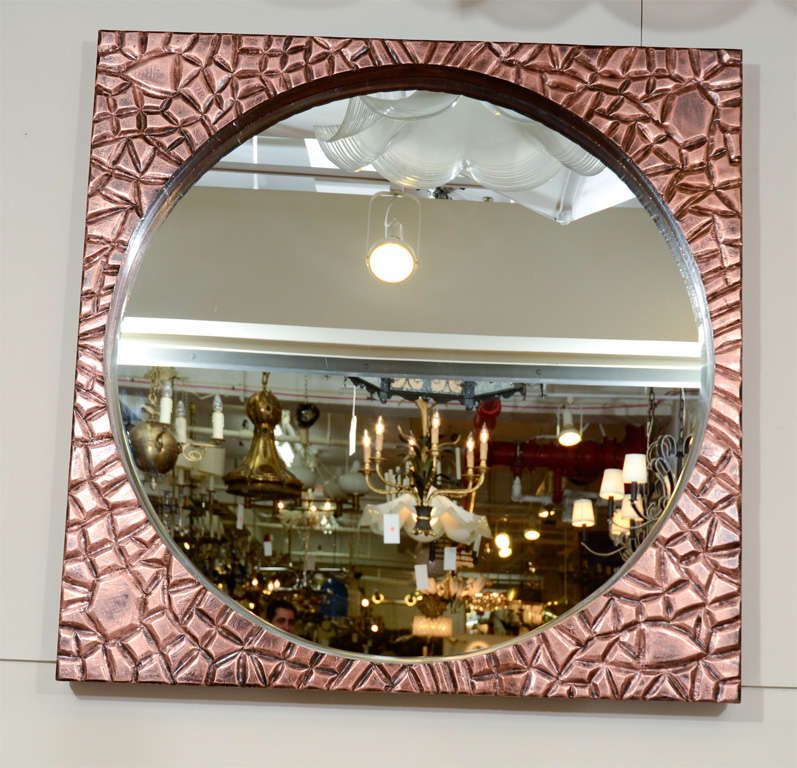 A large, circular wall mirror with a textured frame in bright copper, the patinated surface giving the piece a uniquely rusticated appearance. Very good vintage condition, wear consistent with age and use.

4375.