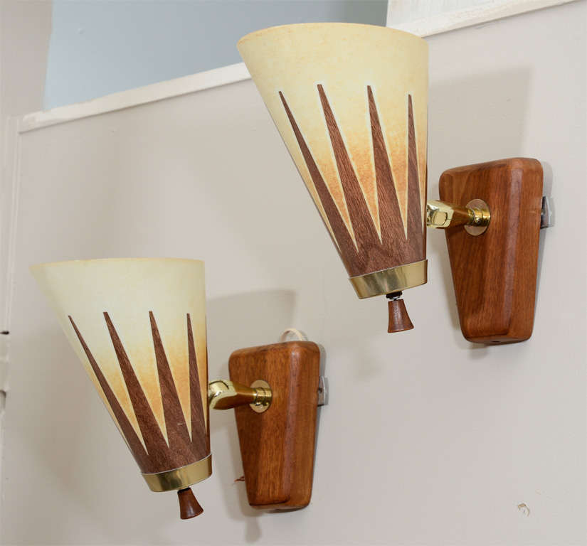 A pair of wood mounted wall sconces with brass detailing. The light shades are articulated and can be rotated or angled.

Reduced From: $1,250