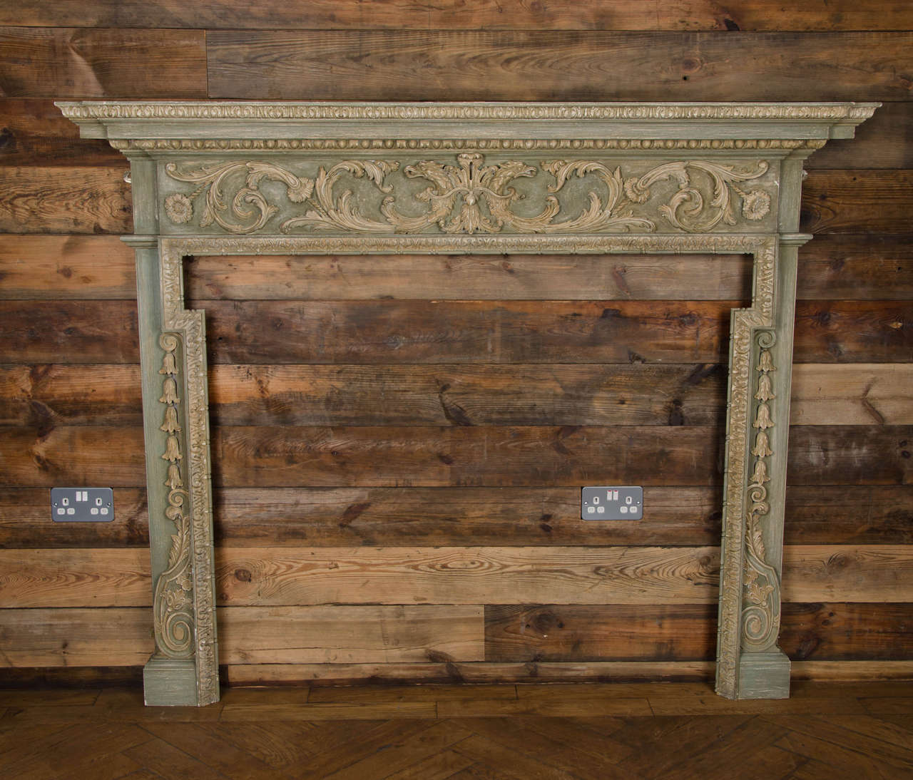 A magnificent Georgian style fireplace surround in wood. This intricately carved wooden fire surround features a breakfront shelf with acanthus leaf trim and a spectacularly, finely carved frieze of detailed acanthus leaves and flowers. The slim,