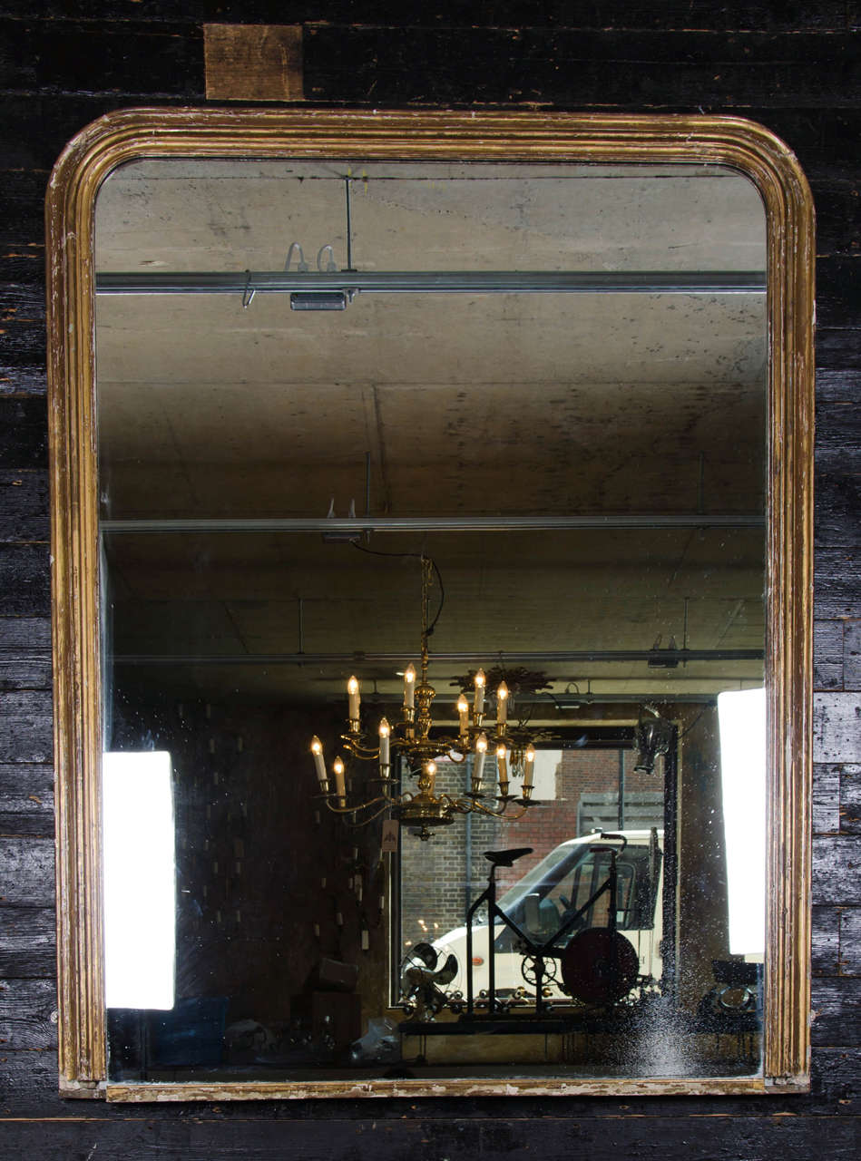 A large traditional Victorian overmantel mirror with a gilt gold-painted frame. This well proportioned antique mirror has an elegantly slim, simple frame and an understated design making it a wonderful piece for a range of interior styles.