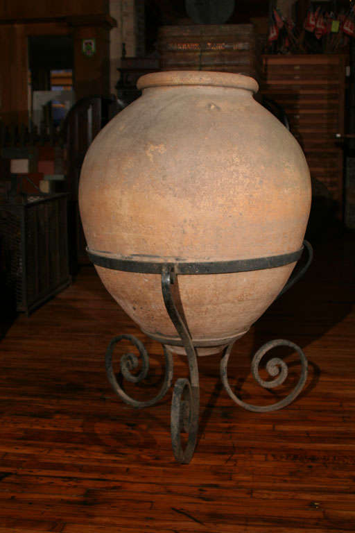 Clay wine vessel from a Jesuit monastery. Has Jesuit inscription. 19th century, iron base is newer.