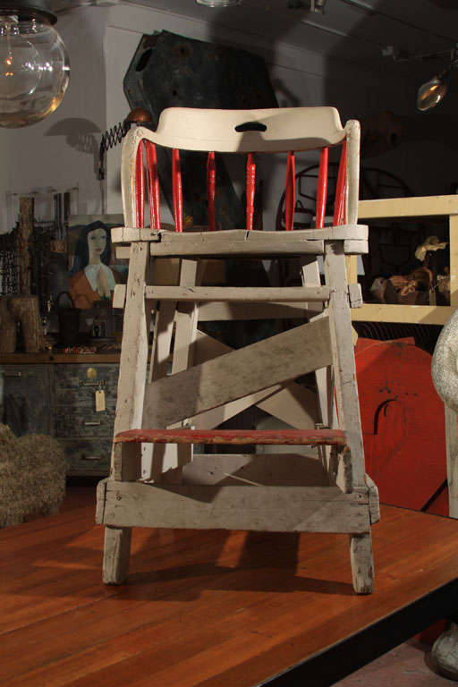 A truly one-of-kind utilitarian creation,  this homemade lifeguard chair was created from a spindle-back pub chair and wooden planks with several generous coats of gray and red paint.