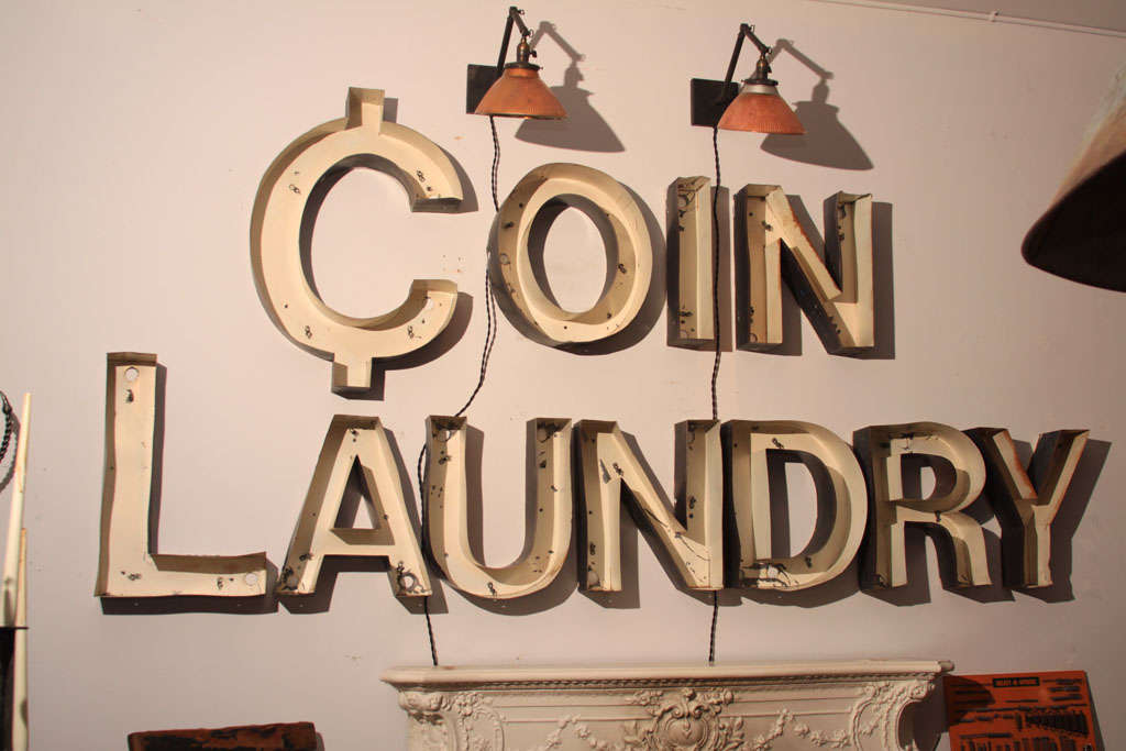 Vintage neon sign from a small-town laundromat reading 'Coin Laundry'; the C in Coin is in the shape of a cent symbol.