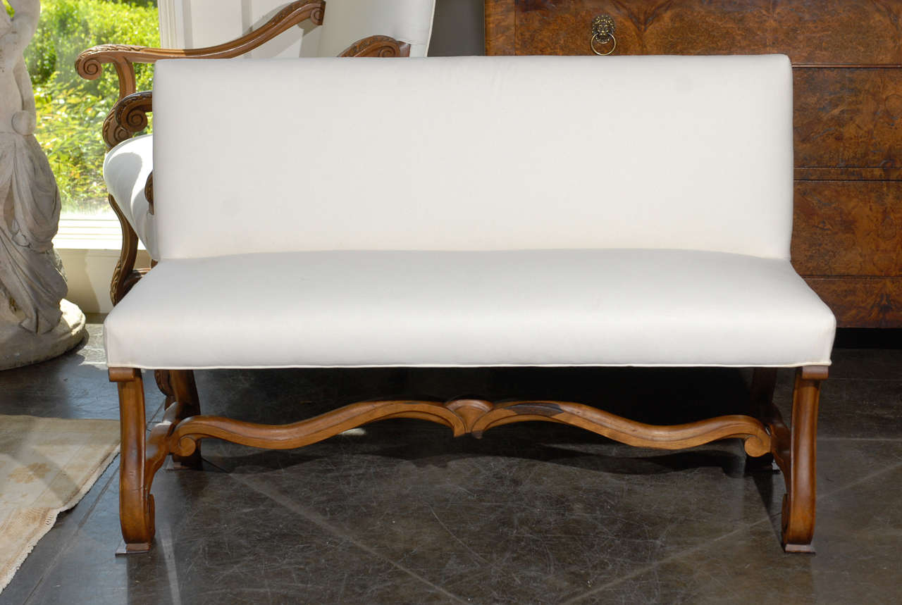 French curved leg upholstered bench / settee with a back and stretcher. The upholstery is new.