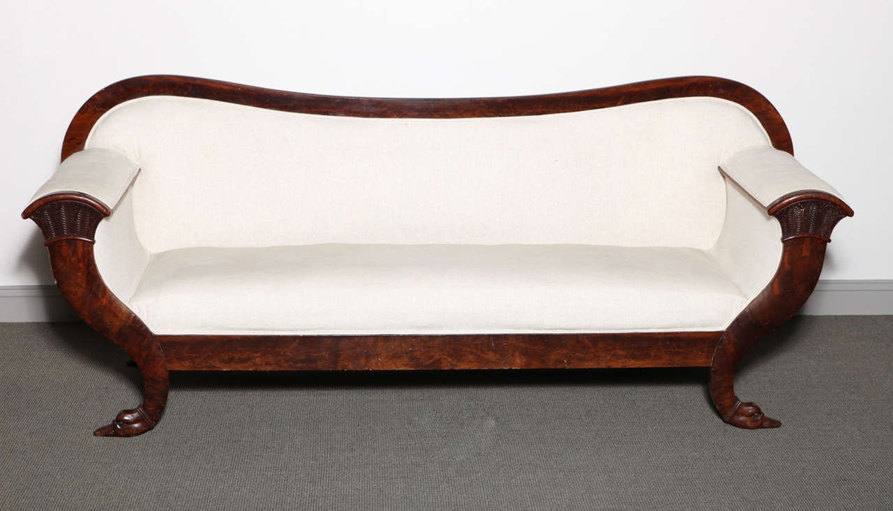 Biedermeier carved mahogany frame sofa with a curved back and swan detail at the feet. The frame is finished on both sides. Currently upholstered in cream linen.