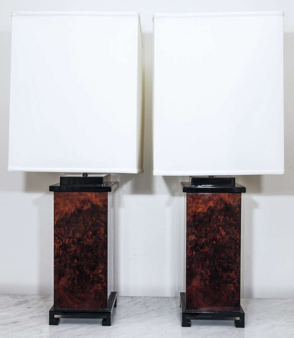 Two very large single-light table lamps with bodies in acrylic to simulate burled wood; bases and caps in black lacquer; base measures 8.25 x 8.25; shades in ivory hard-back linen; measurements include the shades