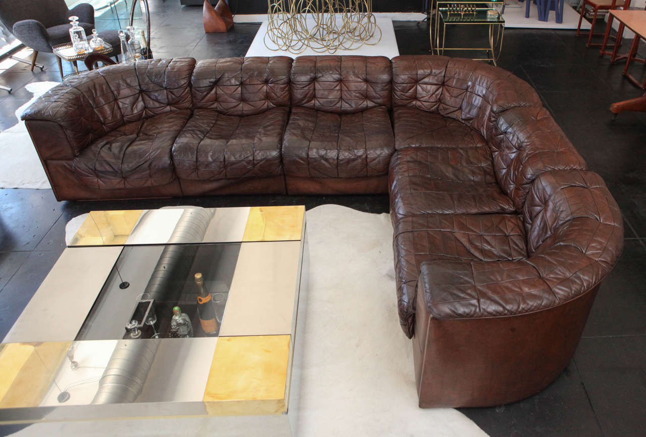 Amazing 1970s Aged Brown Leather Six-Piece Sectional Sofa. Three curved corner pieces and three straight pieces.  

9'6
