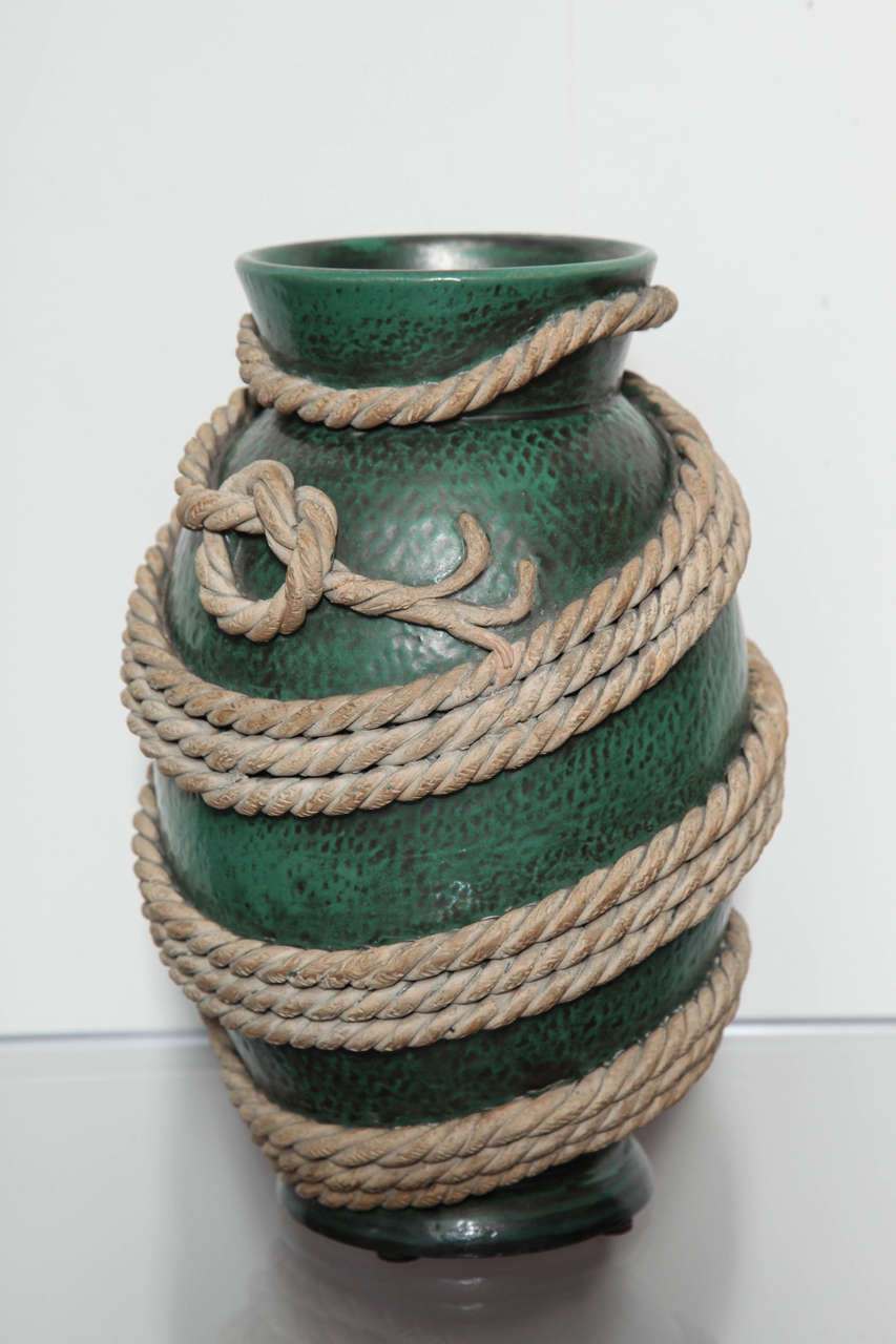 Gorgeous terra cotta vase with wide mouth and footed base. Textured surface with matte green glaze and applied ceramic rope throughout. These rope vases are highly sought after pieces and this example is a great scale, and condition. Signed on