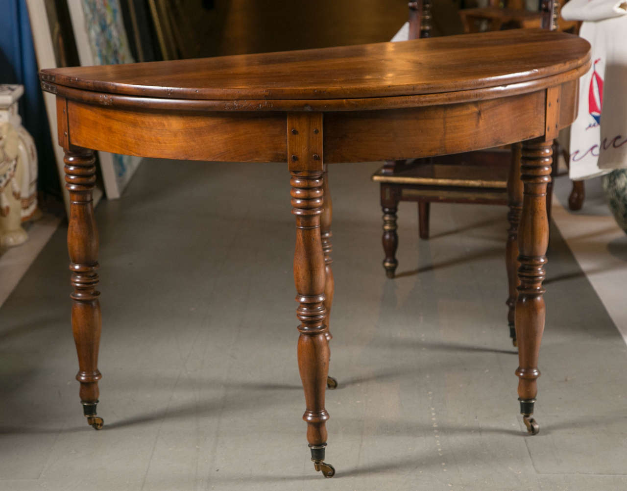 A beautiful red maple French fold over dining and games table. With original casters, circa 1870s.