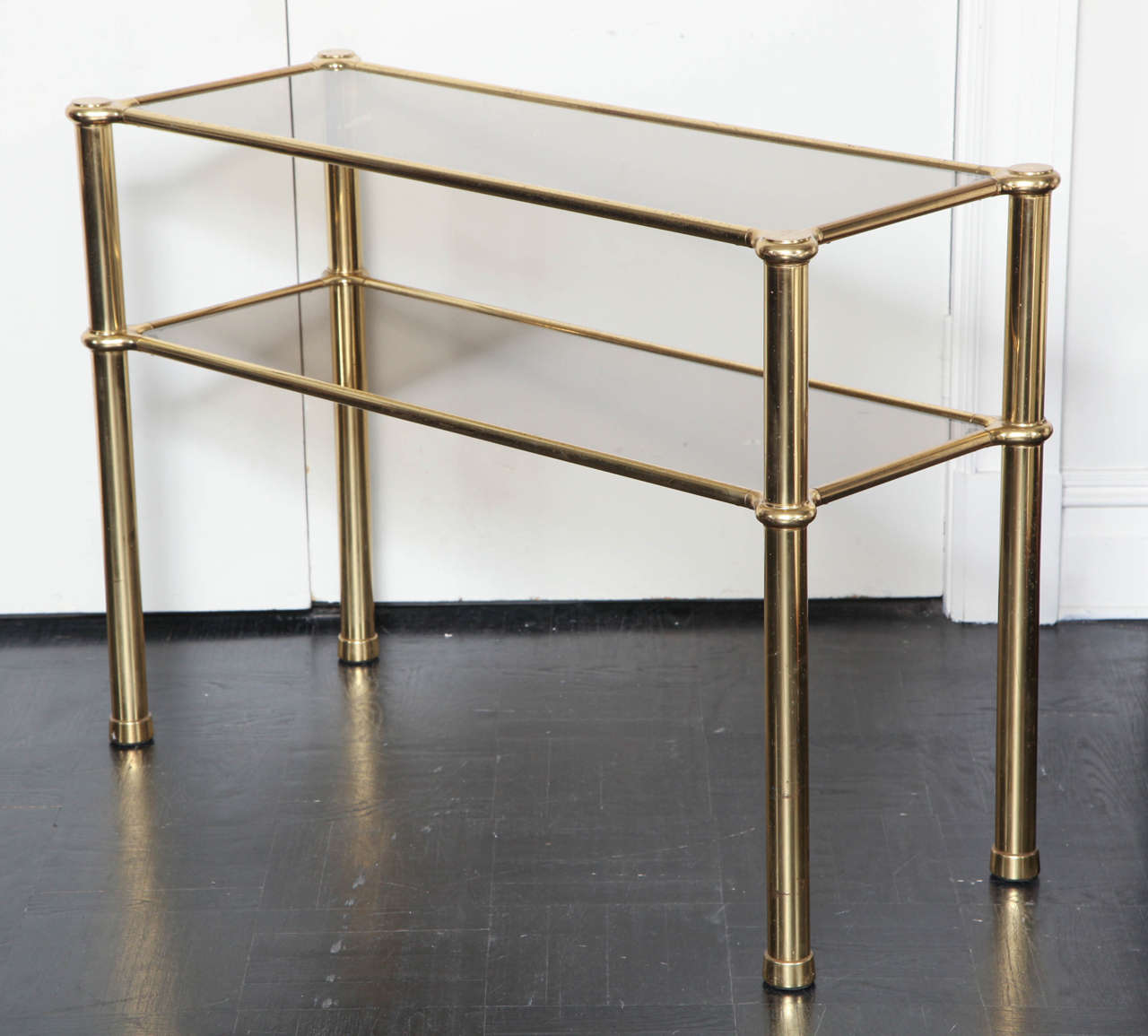 Mid-20th century polished gilt brass and smoked glass two-tier console table.