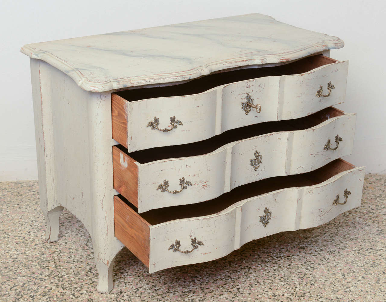 Gorgeous Small Baroque chest with curved rounded top edge that extends over three curved drawers; has four curved legs and original locks.
Painted in Swedish white/ greyish distressed paint finish, top is faux marble paint finish.
Lovely brass