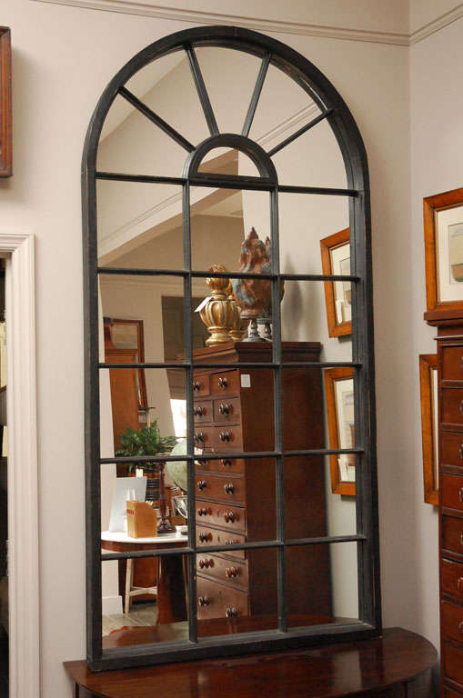 A pair of elegant Palladian style arched window frame mirrors with black painted frames