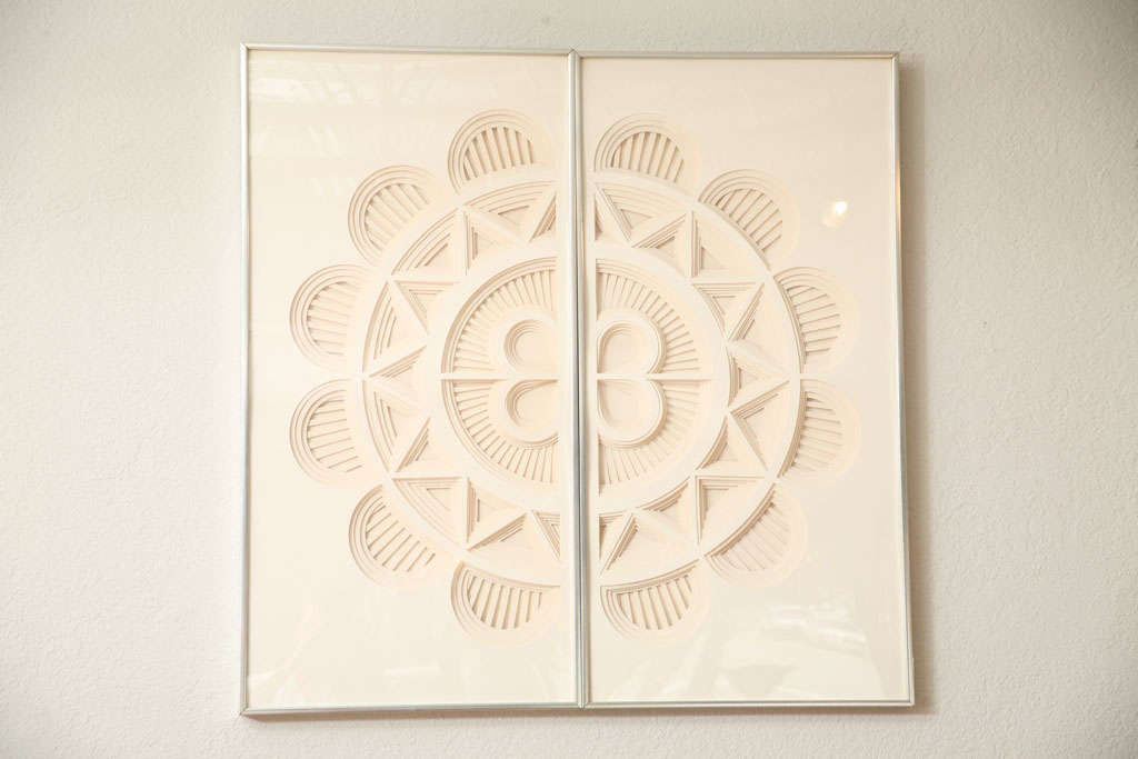 Layers of painstakingly hand-cut mat board are placed one on top of the other to form these subtly graphic wall pieces by Nancy Miller. Three pieces in total, two hanging together form a circle (as shown), all three together form a capsule shape <br