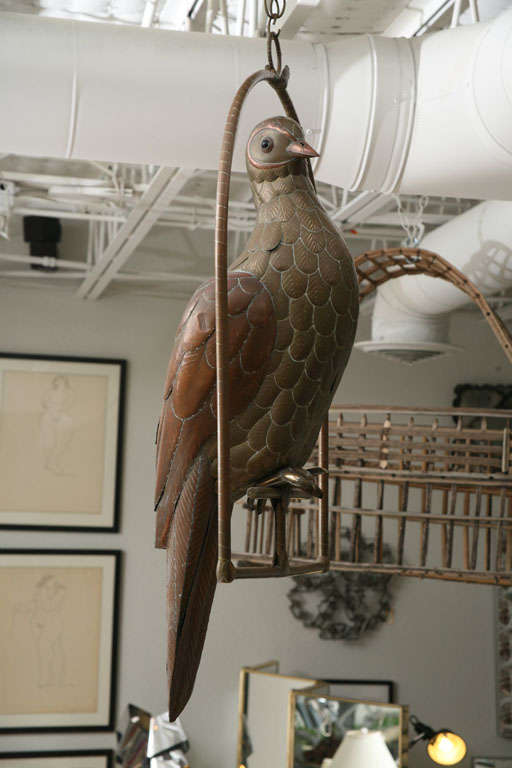 Handsome and serene copper and brass dove designed by Sergio Bustamante rests on its own hanging perch. Wonderful scale, modelling, and detail.