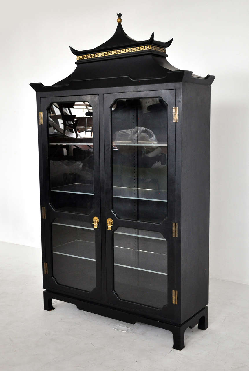 Vintage chinoiserie vitrine.  Black cabinet with brass hardware and gold details.  Interior shelves are lucite.