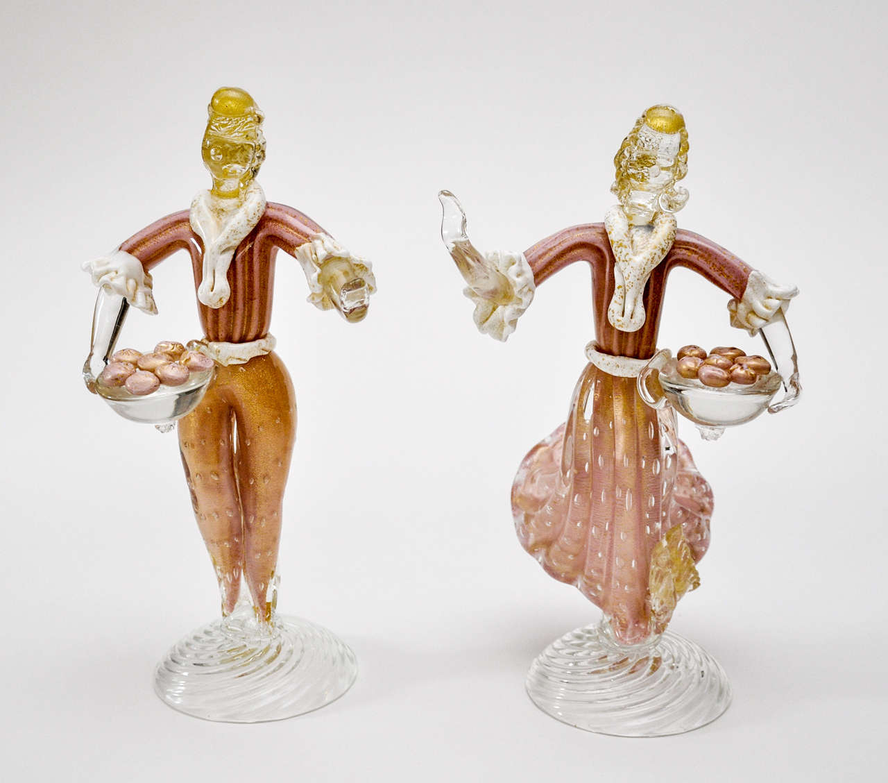 Pair of matched, man and woman, Murano glass figurines. Rose color with flecks of gold throughout figures.