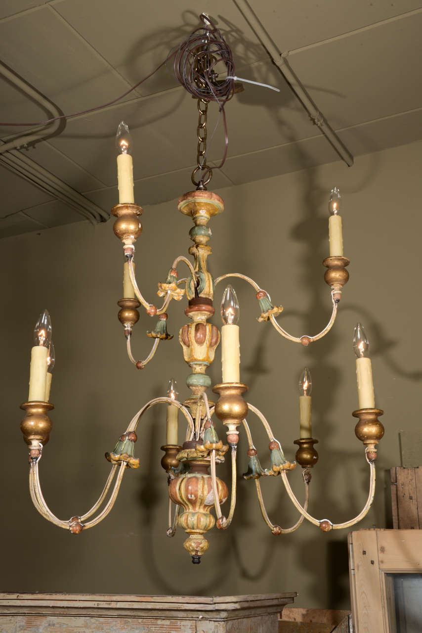 Iron and carved wood chandelier from Genoa. Gilded and painted in blues and ochre.