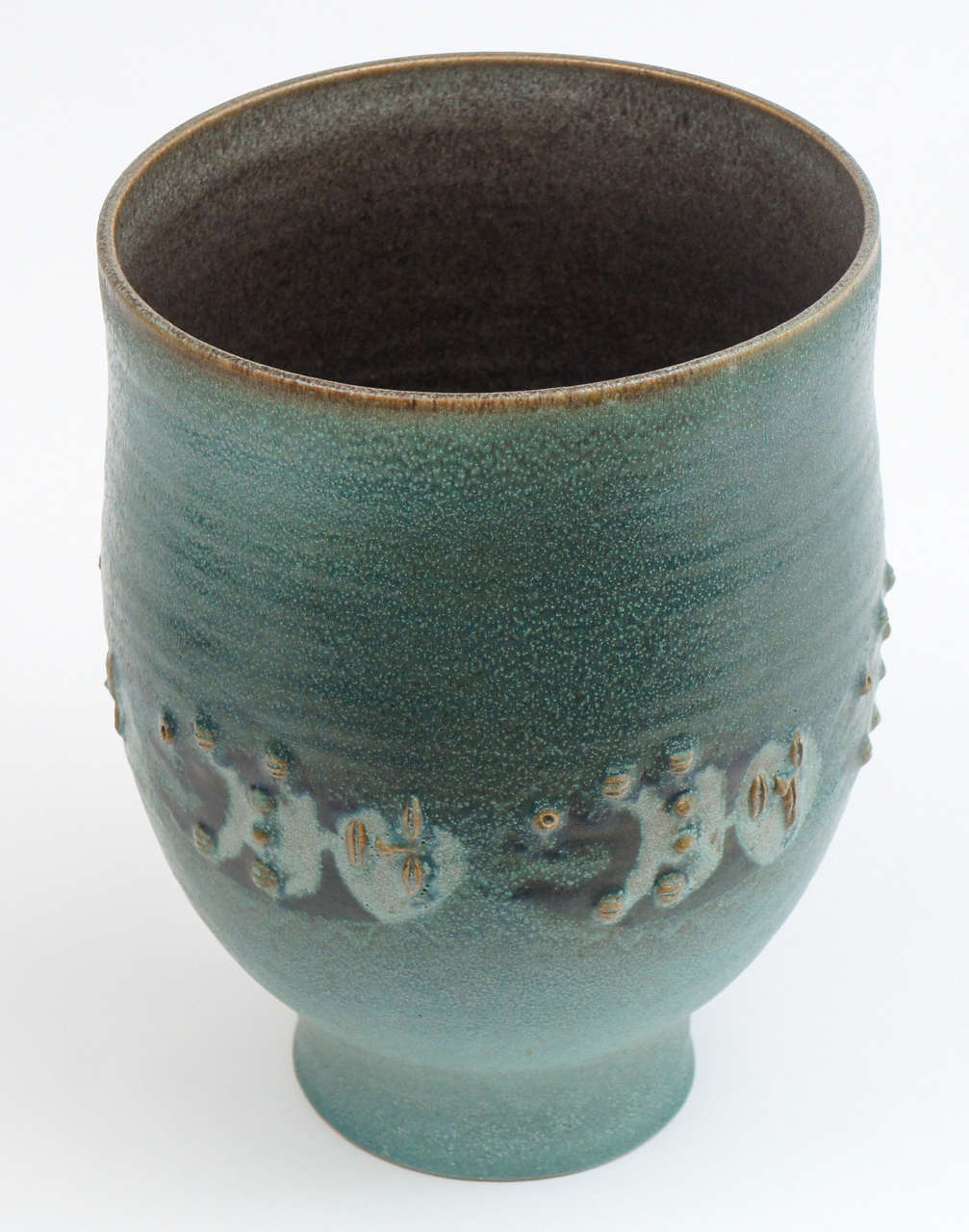 Dramatic piece by Edwin and Mary Scheier, important studio potters of the 20th century. This highly stylized creation is in a soft. Muted green adorned with raised figures around the central portion. This piece is signed and special!