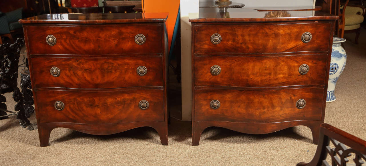 A fine pair of custom quality Georgian Style Bachelor Chest by Baker furniture company. The sprayed feet supporting an oak secondary shell with crotch mahogany veneers. Having three drawers. Can be used as commodes or nightstands. Finely polished.