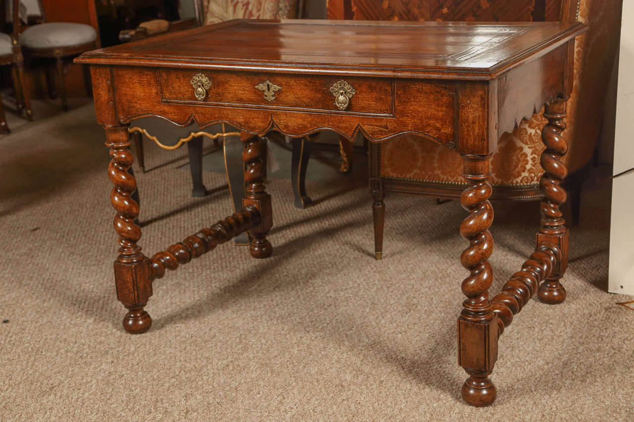 A 19th century William and Mary desk. Finely tooled leather top above a single drawer. The barley twist legs with a knee hole center opening. This piece in wonderful condition having been professionally restored recently removed from a Connecticut