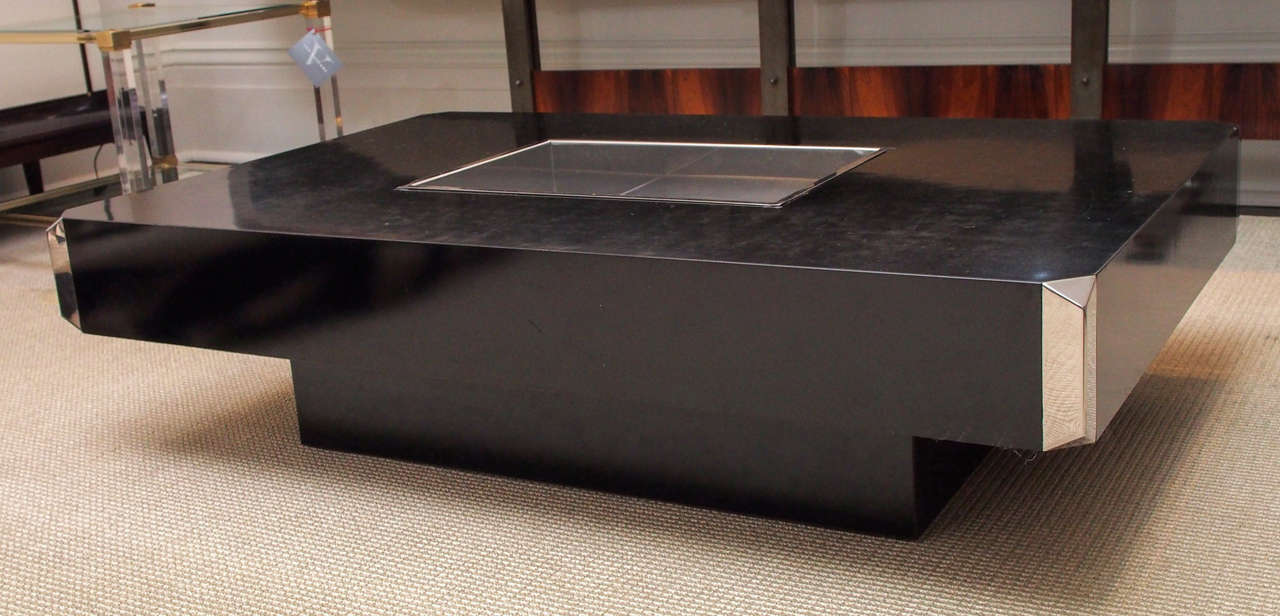 Iconic cocktail table in black laminate with rectangular steel insert at the center and steel details at the corners