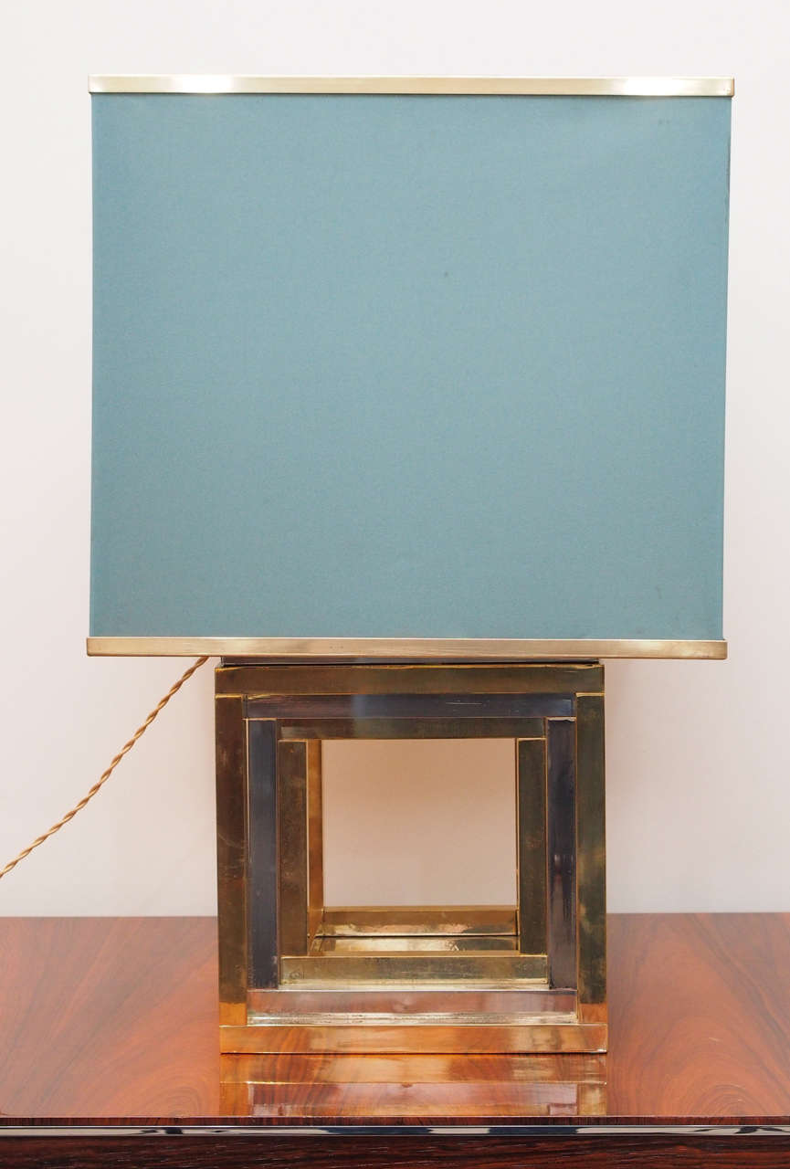 Handsome pair two light table lamps with bases in alternate inset cubes of brass and chrome; original shade in teal polyester with brass trim; note that cord extends from base of socket; measurements include the shade