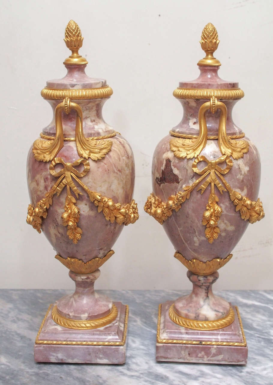 19th century French gilt bronze mounted marble garniture urns with floral swags, double handles, finials and engine turned rings.