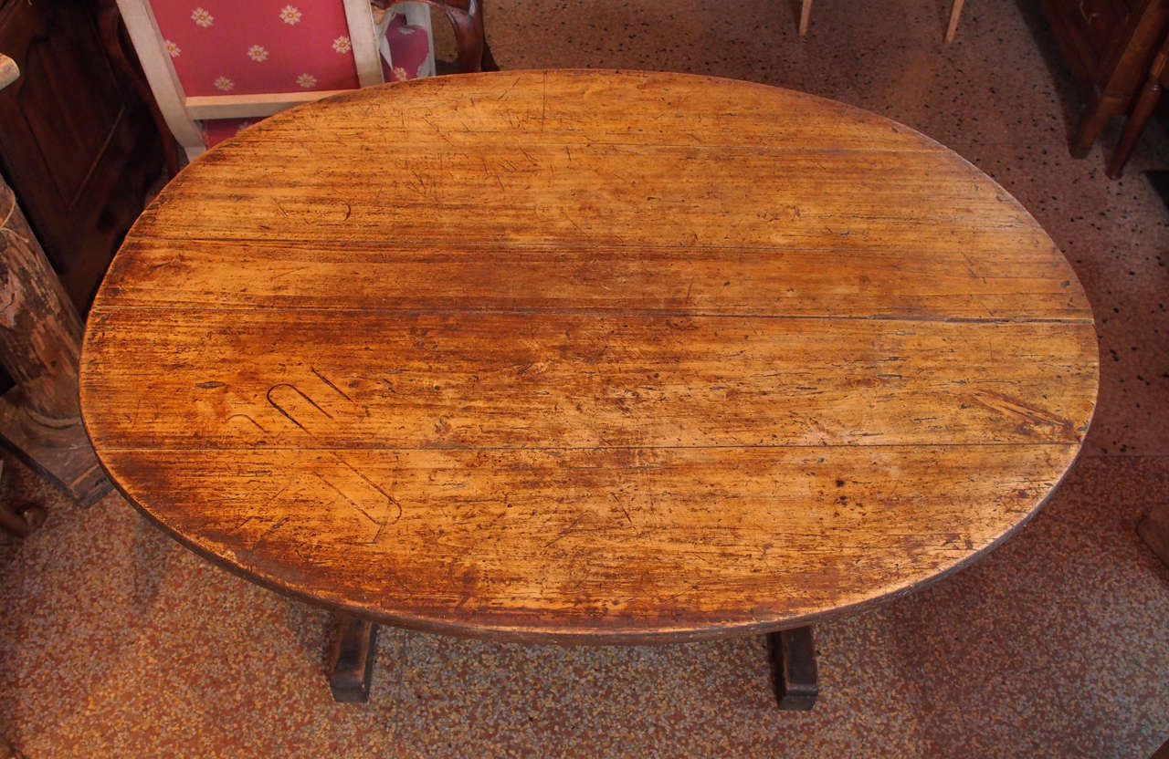 19th century Oak wine tasting table, oval in shape, raised on two trestle legs.
H shaped stretcher under the top serves to tilt the top in a vertical position.